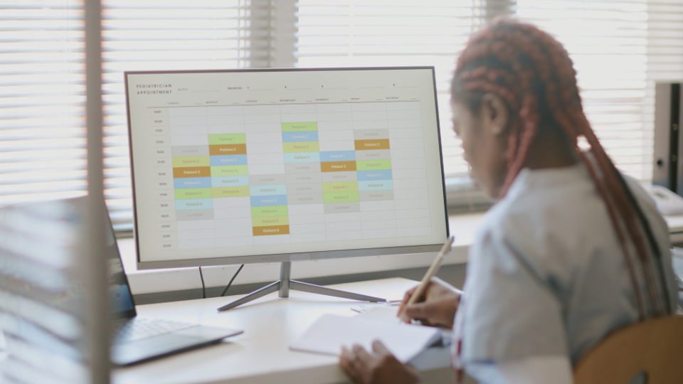 Receptionist Using Scheduling Software Showing What AI Booking Agents Can Improve